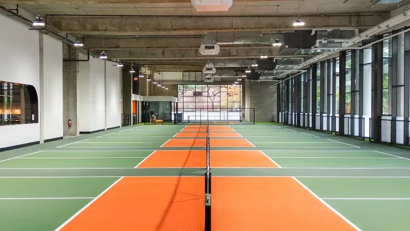 Indoor pickleball facility with orange courts