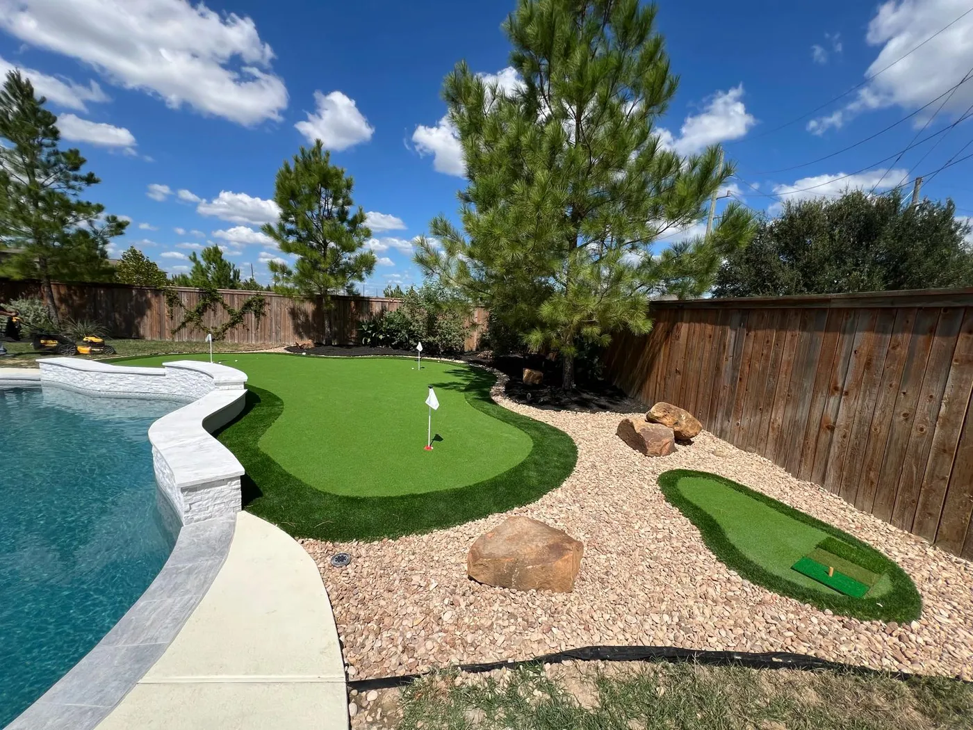 Backyard putting green beside a pool